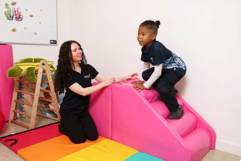Child doing gross motor play with a therapist